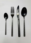 Paniery black 24-piece cutlery set with Adinkra symbols, featuring crossed pattern and wave motif.