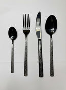 Paniery black stainless steel cutlery set with Adinkra wave pattern, includes fork, knife, and spoons.
