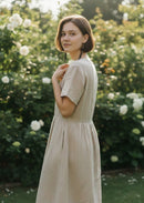 Paniery handcrafted earrings made from upcycled brass and natural materials, worn by a model in a garden setting.