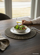 Paniery beaded placemat in dark grey with a sunburst pattern, handcrafted for elegant table settings.