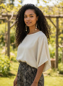 Paniery handcrafted teardrop brass earrings with stacked cowrie shells and black bead accents.