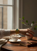Paniery handmade brass cuff bracelet with a round, faceted green stone inset. Recycled metal.