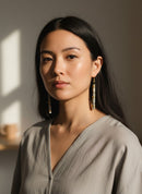 Paniery handcrafted grey wood and brass statement earrings with black bead accents.