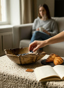 Paniery hand-carved wooden sun bowl with organic design, filled with blueberries. A decorative and functional centerpiece.