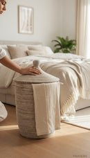 Paniery handwoven laundry basket in natural tones with leather handles, made from recycled plastic and sea grass.