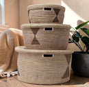 Paniery handwoven Senegalese storage baskets made from recycled plastic and seagrass. Natural beige and brown woven texture with geometric pattern and handles.