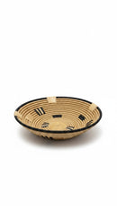 Paniery handwoven wall basket made from natural fibers with black accents and a black rim. Round, shallow design.