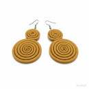 Paniery mustard yellow handwoven spiral statement earrings with a textured finish.