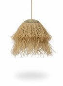 Paniery handwoven natural raffia lampshade with a unique organic shape and fringed hem, casting a soft diffused light.