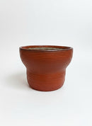 Paniery handwoven drum-inspired basket in orange leather, seagrass, and recycled plastic. Features ribbed texture and a wide opening.