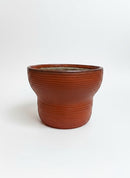 Paniery handwoven drum-inspired basket in orange leather, seagrass, and recycled plastic. Features ribbed texture and a wide opening.