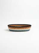 Paniery oval handwoven basket with natural fibers in blue, tan, and black stripes. Ideal for table or home decor.