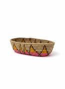 Paniery oval handwoven basket in natural fibers with pink and yellow geometric pattern. Ideal for serving or decor.