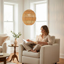 Paniery handwoven natural raffia pendant lampshade, spherical, creating ambient light in a living room.