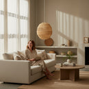 Paniery handwoven natural raffia lampshade, spherical design, creates ambient light in a living room.