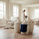 Paniery Senegal handwoven laundry basket made from recycled plastic and natural fibers with leather handles. Three sizes shown in a bright, minimalist room.