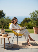 Paniery Signature Solis Chair in bright yellow, handwoven from recycled fishing lines, with a striking radial design, perfect for indoor/outdoor use.
