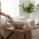 Paniery handwoven natural sweetgrass basket with black sunburst design, 50 cm diameter, used as wall art or table decor.