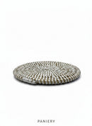 Paniery handwoven white and natural straw round coaster with a spiral pattern. Durable and elegant table accessory.