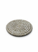 Paniery handwoven white round coaster made from natural fibers with a spiral pattern. Durable and elegant table accessory.