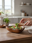 Paniery handcrafted wooden heart bowl with zebra stripe inlay, serving a fresh salad.