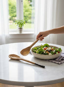 Paniery handcrafted wooden salad servers, one slotted, with dark accents on handles, shown with a salad bowl.