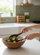 Paniery hand-carved wooden salad servers with colourful Maasai beadwork handles, serving a salad.
