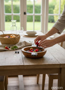 Paniery handcrafted wooden serving bowl with handles, filled with fresh berries on a rustic wooden table.