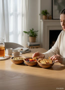 Paniery handcrafted wooden triple serving bowl with African multi-section design, filled with pistachios, dried fruit, and crackers.