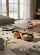 Paniery handcrafted wooden triple serving bowl with African multi-section design, filled with pistachios, cranberries, and oats with chocolate chips.