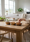Paniery handcrafted wooden triple serving bowl with African multi-section design, filled with olives, nuts, and dried fruit.