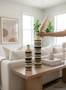 Paniery handwoven African floor vase with black and natural stripes, made from natural fibers. Tall statement piece.